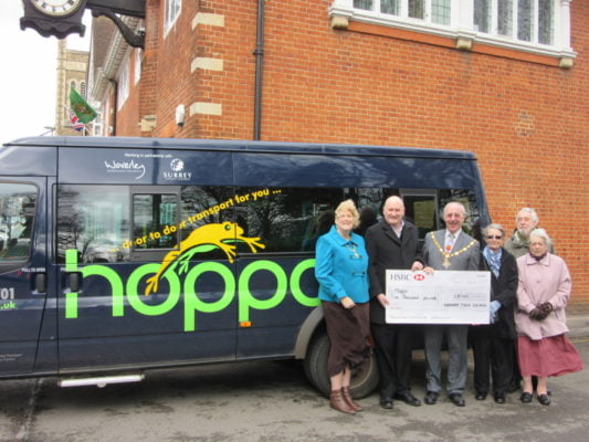 People in front of bus receiving a cheque.