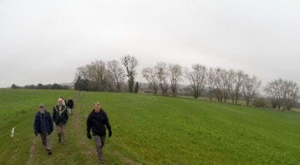 People in field with trees in background. Winter scene