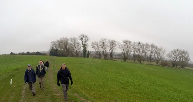 People in field with trees in background. Winter scene