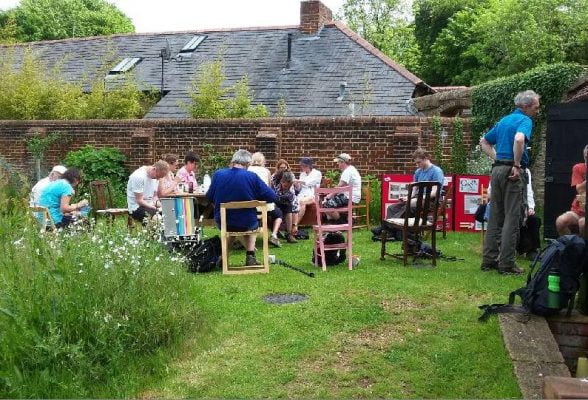 People sitting at tables in a garden.