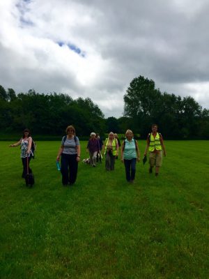People walking across grassland.