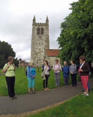 Walkers in churchyard. Church behind.
