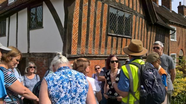 People in front of a timber framed building