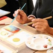 Close up of person's hands painting.