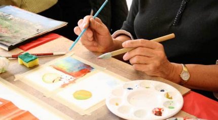 Close up of person's hands painting.