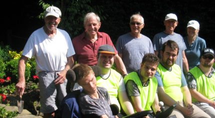 Group of people sitting in a garden.