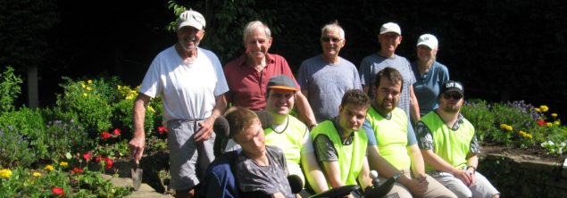 Group of people sitting in a garden.