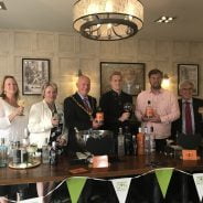 Mayor and group of people holding gin glasses.