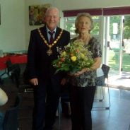 Mayor presenting female with a bouquet of flowers.