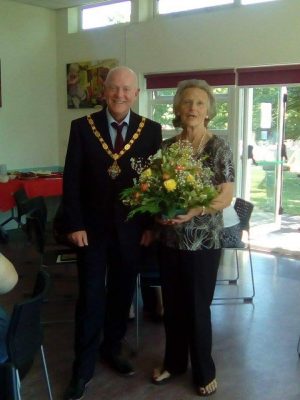 Mayor presenting female with a bouquet of flowers.