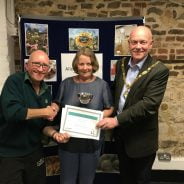 Female being presented with a certificate by the Mayor and a male.