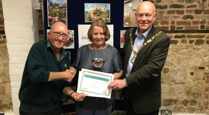 Female being presented with a certificate by the Mayor and a male.