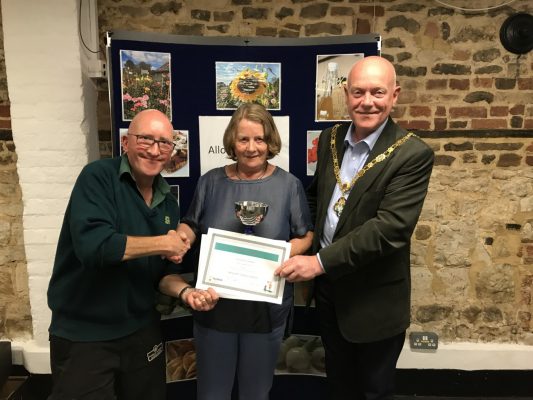 Female being presented with a certificate by the Mayor and a male.