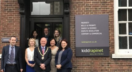 Group of people with Mayor standing outside an office.