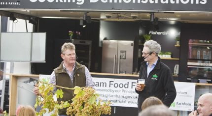 Two males - one holding a hop branch and one holding a beer.