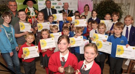 Group of children holding certificates and a trophy.