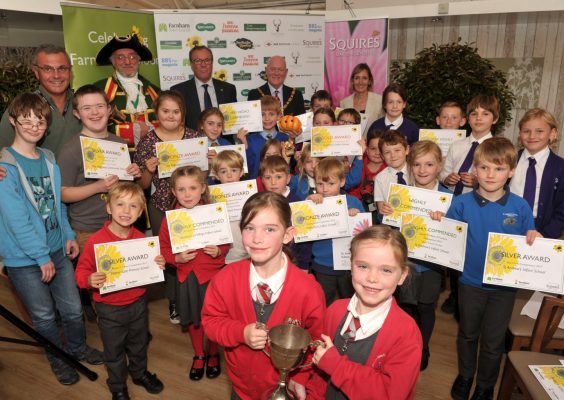 Group of children holding certificates and a trophy.