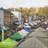 Aerial view of a crowded market with people and marquees.