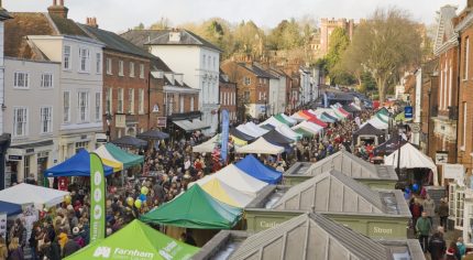 Aerial view of a crowded market with people and marquees.