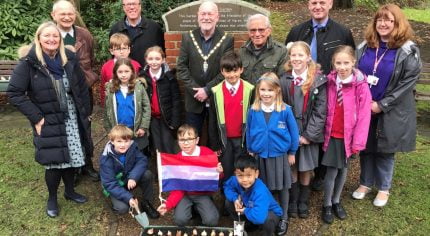 Schoolchildren with Dutch flag and container of tulip bulbs