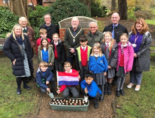 Schoolchildren with Dutch flag and container of tulip bulbs