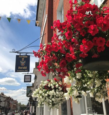 Hanging baskets with red and white flowers in West Street, Farnham