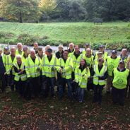 Group of people in high viz jackets holding sacks and litter picks