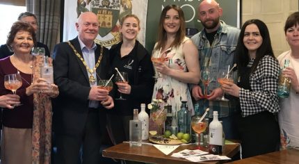 Group of people holding gin glasses.