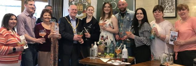 Group of people holding gin glasses.