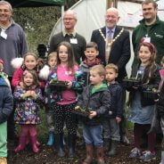 Group of children and adults outside a poly tunnel.