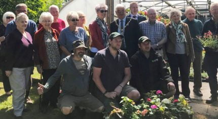 People standing outside a poly tunnel.