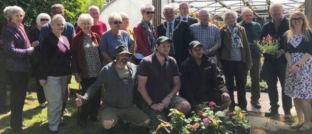 People standing outside a poly tunnel.