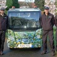 Group eight males standing next to a vehicle with flowery livery.