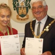 Young girl holding a certificate with the Mayor on her left.