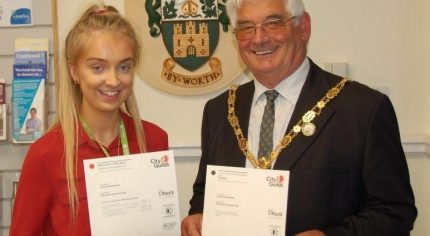 Young girl holding a certificate with the Mayor on her left.