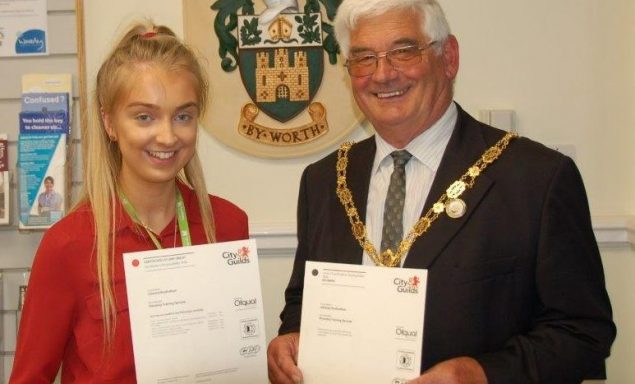 Young girl holding a certificate with the Mayor on her left.