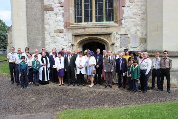 Group of people in smart clothing outside a church.