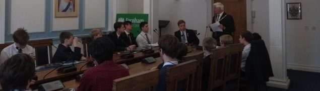 School children sitting around a conference table.