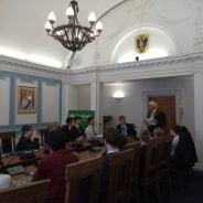 School children sitting around a conference table.