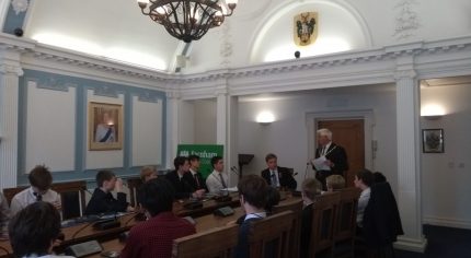 School children sitting around a conference table.