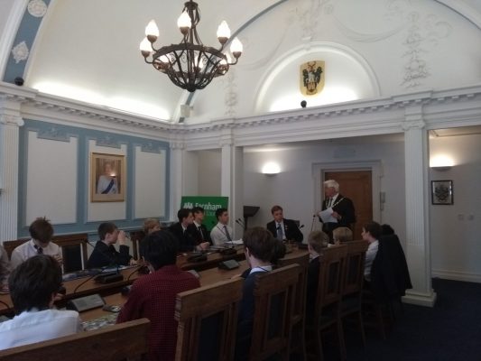 School children sitting around a conference table.