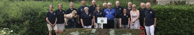 Group of people standing behind a carpet bed