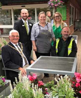 Mayor and group of people sitting at table outside Waitrose