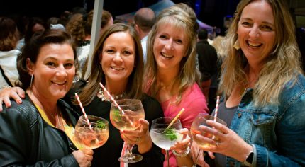 Four females holding gin glasses.