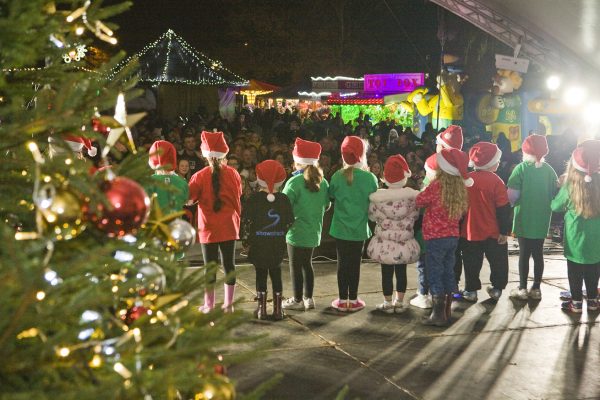 Back of children on stage. Christmas tree.