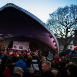 Crowd of people watching drummers perform on stage