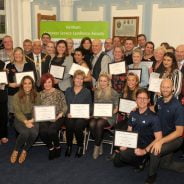 Group of people holding certificates.