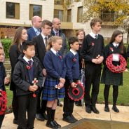 School children holding poppy wreaths