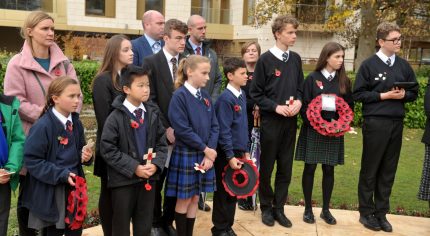 School children holding poppy wreaths