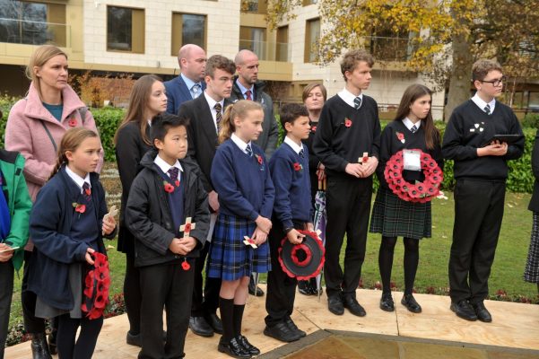 School children holding poppy wreaths